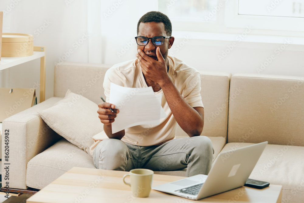 Smiling African American Man Working on Laptop in Modern Home Office Smiling African American Man Working on Laptop in Modern Home Office