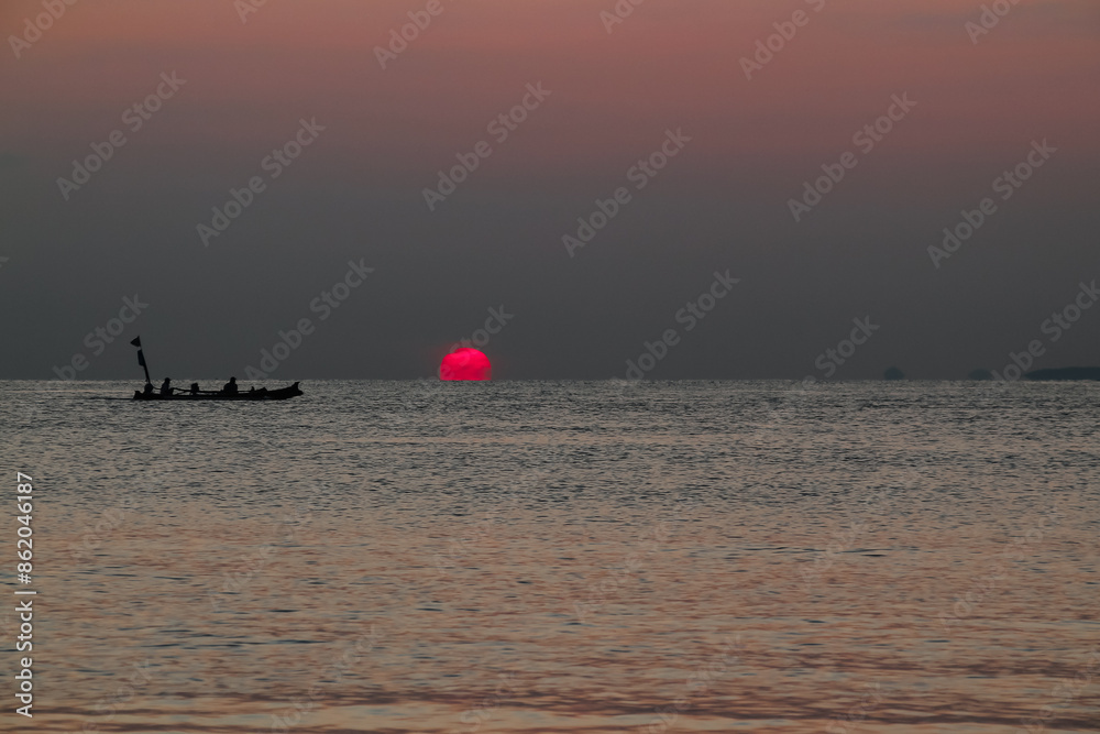 Fototapeta premium Beautiful sunrise on the sea and silhouette of a fishing boat