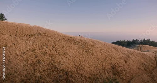 Male and female ballet dancer doing contempoary dance on dry grassy hills in Mt Tamalpais as sunset. San Francisco, California, United States of America. photo