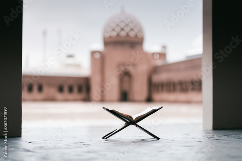 Islamic concept - The Holy Al Quran at beautiful mosque with written Arabic calligraphy meaning of Al Quran and rosary beads or tasbih, Arabic word translation: The Holy Al Quran (holy book of Muslim)
