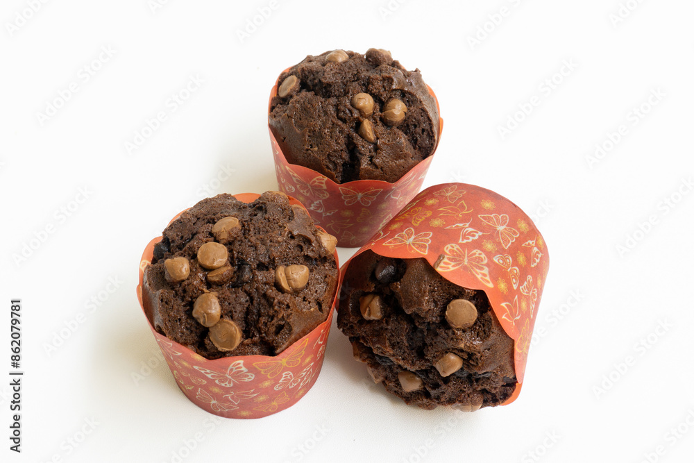 Three chocolate muffin isolated on a white background with copy space. Homemade fluffy and moist chocolate cakes. Three chocolate muffin isolated on a white background with copy space. Homemade fluffy and moist chocolate cakes.