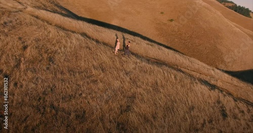 Male and female ballet dancer doing contempoary dance on dry grassy hills in Mt Tamalpais as sunset. San Francisco, California, United States of America. photo