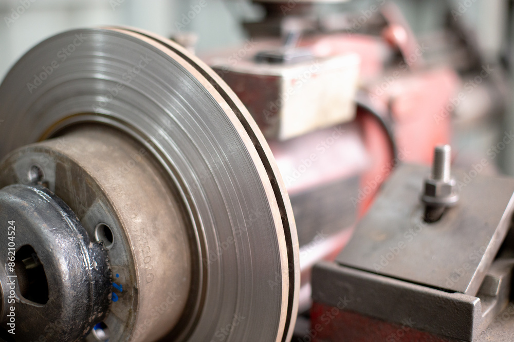 Car brake disc, Lathe tool polishing disc brakes, mechanic maintenance repair steel part wheel of car in garage. Car brake disc, Lathe tool polishing disc brakes, mechanic maintenance repair steel part wheel of car in garage.