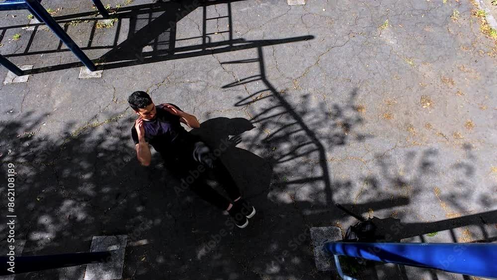 young fitness man doing abdominal exercise on the floor of a park in the city young fitness man doing abdominal exercise on the floor of a park in the city