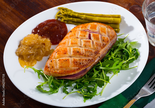 Delicious baked duck breast Magre with arugula, asparagus and sauces at plate photo