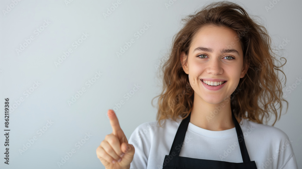 Smiling woman wearing an apron points to the right. Smiling woman wearing an apron points to the right.