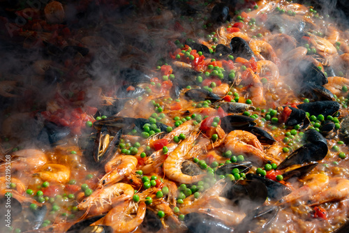 Street food in London, food court on Portobello road Saturday market, fresh prepared colorful paella with rice and sea food big pan, ready to eat