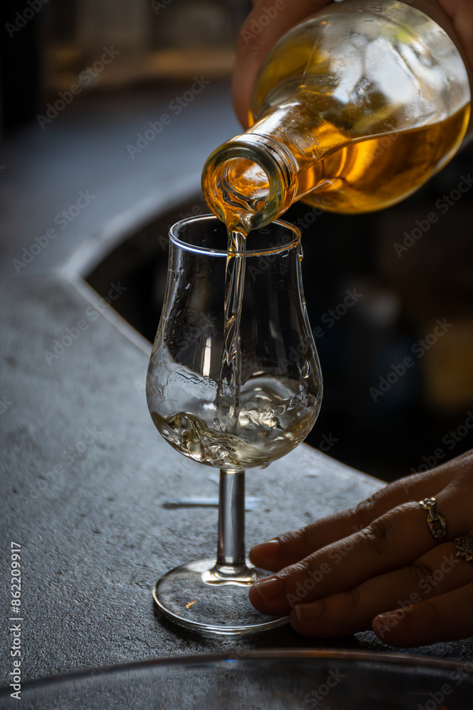 Obraz premium Tasting of cognac spirit aged in old dark French oak barrels in cellar distillery house, Cognac white wine region, Charente, Segonzac, Grand Champagne, France