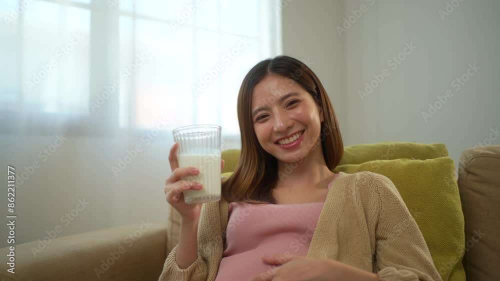 Happy pregnant woman drinking milk and caressing her belly while sitting on sofa at home, concept of healthy mother taking health care and nourish her fetal and waiting her childbirth.
Happy pregnant woman drinking milk and caressing her belly while sitting on sofa at home, concept of healthy mother taking health care and nourish her fetal and waiting her childbirth.
