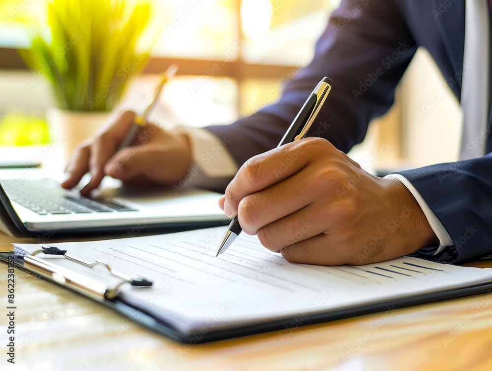 A businessman is writing on a piece of paper. A businessman is writing on a piece of paper.