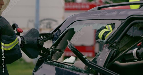 A skilled team of firefighters employs specialized tools and quick reactions to successfully extricate a person trapped in a car, showcasing their heroism and precision in a high-stakes rescue photo