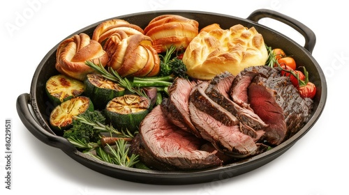 Modern Sunday roast with sliced roast beef cold cuts, Yorkshire pudding, and veggies, isolated