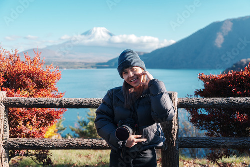 Woman tourist with Fuji Mountain at Lake Motosu in Autumn season, happy Traveler travel Mount Fuji, Yamanashi, Japan. Landmark for tourists attraction. Japan Travel, Destination and Vacation photo