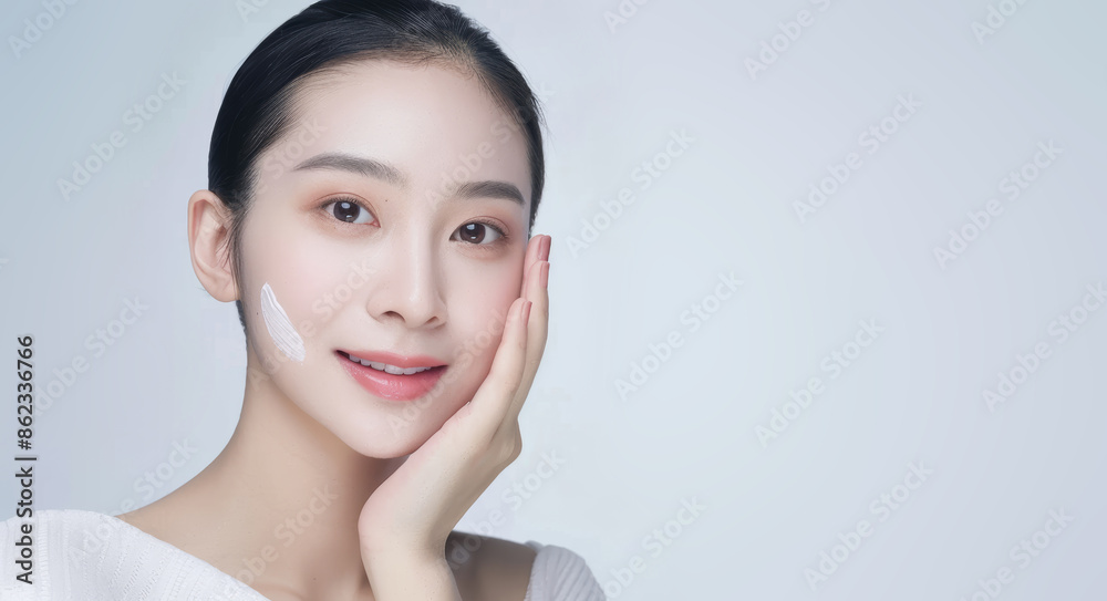 A beautiful Asian woman, with a happy and cheerful demeanor, touches her soft cheek, revealing her clean and fresh skin. Isolated against a white background. A beautiful Asian woman, with a happy and cheerful demeanor, touches her soft cheek, revealing her clean and fresh skin. Isolated against a white background.