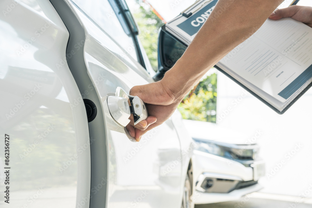 A businessman stands next to his damaged vehicle after an accident, holding a clipboard and examining the scene. An insurance agent arrives to assess the damage and start the claim process. A businessman stands next to his damaged vehicle after an accident, holding a clipboard and examining the scene. An insurance agent arrives to assess the damage and start the claim process.