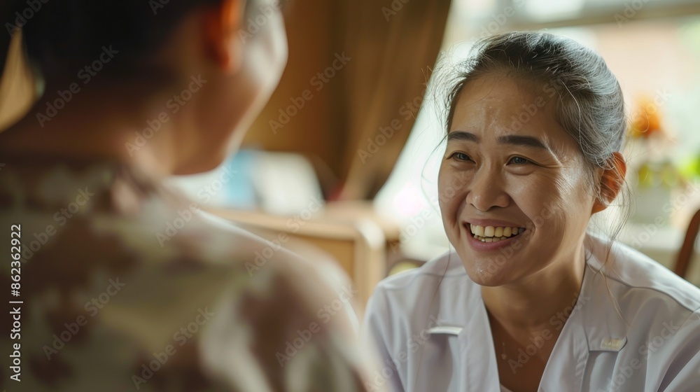 Smiling Asian Nurse Discussing CareElderly Patient in Hospital Setting Smiling Asian Nurse Discussing CareElderly Patient in Hospital Setting