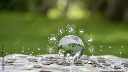 Fototapeta Naklejka Na Ścianę i Meble -  A crystal globe placed on top of a US dollar bill has icons around it with a green background. The concept of environmental investment green business carbon credits