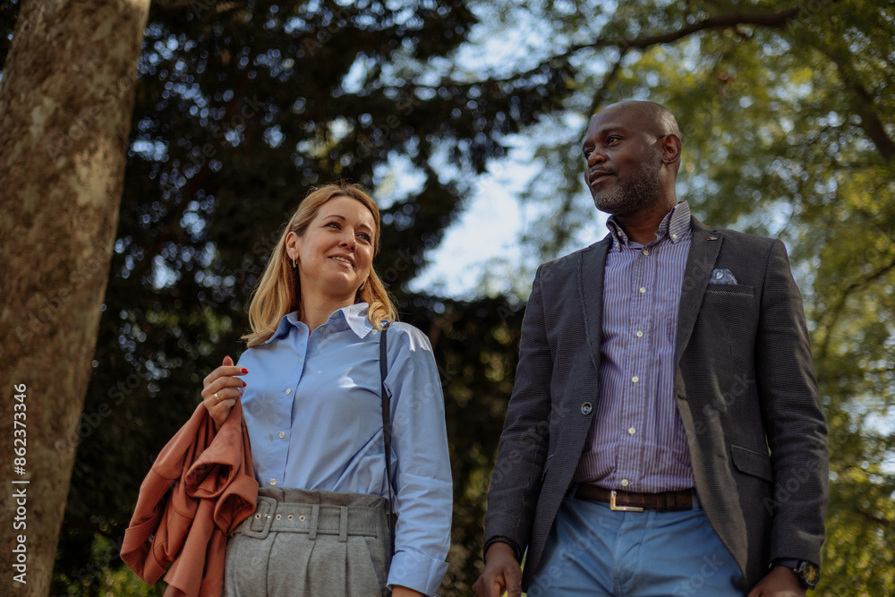 Two businesspeople casually walking in the park Two businesspeople casually walking in the park