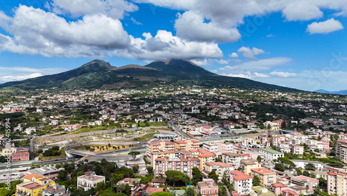 Aerial view of the city of  Portici with the Vesuvius volcano covered by clouds on the background photo