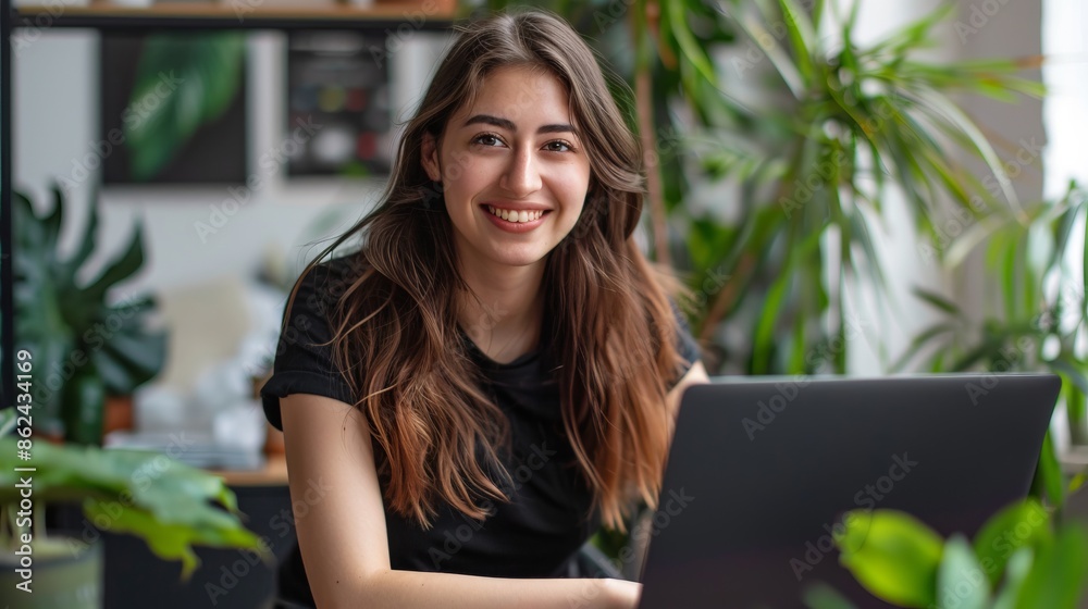 Young woman working remotely on laptop with a smile, surrounded by plants in a home office. This modern image captures the essence of freelance work. Perfect for business or lifestyle use. AI Young woman working remotely on laptop with a smile, surrounded by plants in a home office. This modern image captures the essence of freelance work. Perfect for business or lifestyle use. AI
