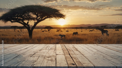 A savanna scene with a large tree in the foreground and a herd of zebras