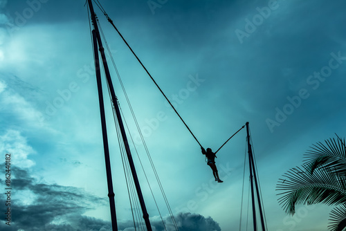 Woman in a reverse bungee attraction, also known as catapult bungee, slingshot, or ejection seat. Medellin, Medellín, Antioquia, Colombia.