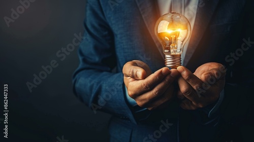 A businessman holds a glowing light bulb in the palm of his hands. AI.