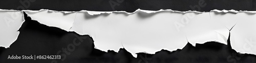 A white piece of paper with torn edges on the left side, isolated against a black background. The top edge is sharp and clear while the bottom edge has slightly rounded corners. photo