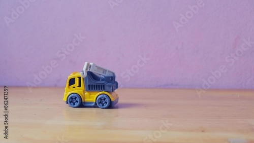 Industrial mechanical yellow crane toy truck drive on wooden table, plaything for kid learning about construction site work and logistic work, copy space