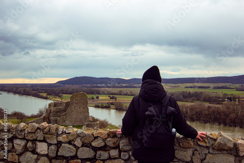 Woman tourist in black outfit at the top of Devin castle (Slovak: Devinsky hrad). The castle  located at confluence of Danube river and Morava River near Bratislava, Slovakia photo