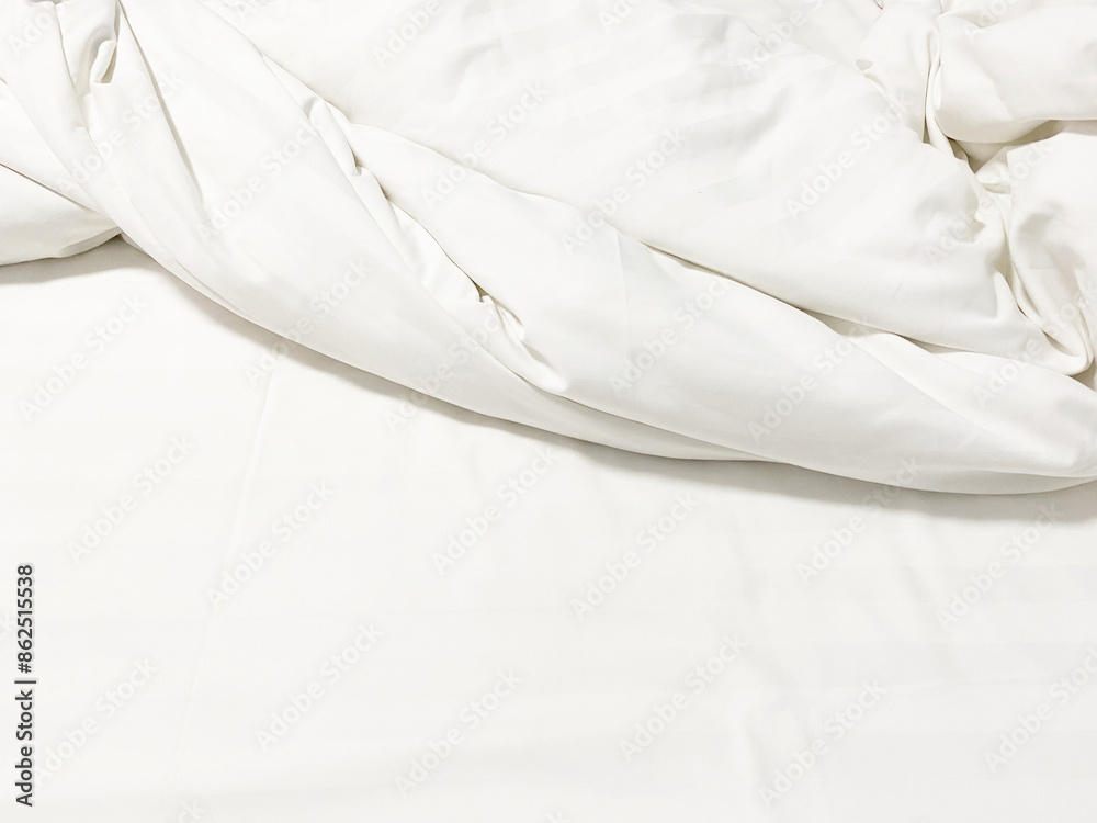 Obraz premium wrinkle messy blanket and white pillow in bedroom after waking up in the morning, from sleeping in a long night, details of duvet and blanket, an unmade bed in hotel bedroom with white blanket