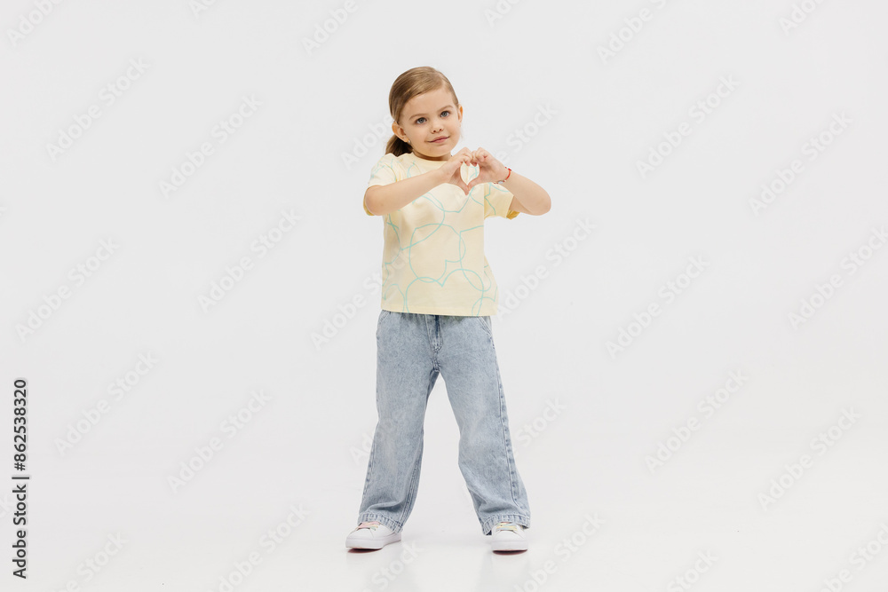Fashionable, stylish little girl dancing, having fun and posing on a white studio background. Fashion, children's clothing and entertainment concept. Fashionable, stylish little girl dancing, having fun and posing on a white studio background. Fashion, children's clothing and entertainment concept.