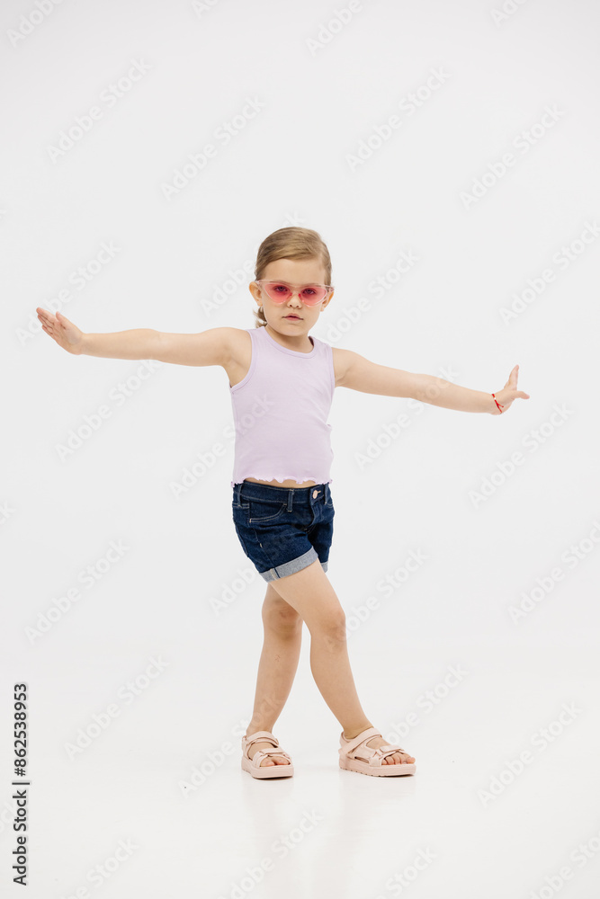 Little girl dancing in the studio on a white background. Happy energetic girl having fun and enjoying her childhood. Concept of fashion, style and happy children's emotions. Little girl dancing in the studio on a white background. Happy energetic girl having fun and enjoying her childhood. Concept of fashion, style and happy children's emotions.