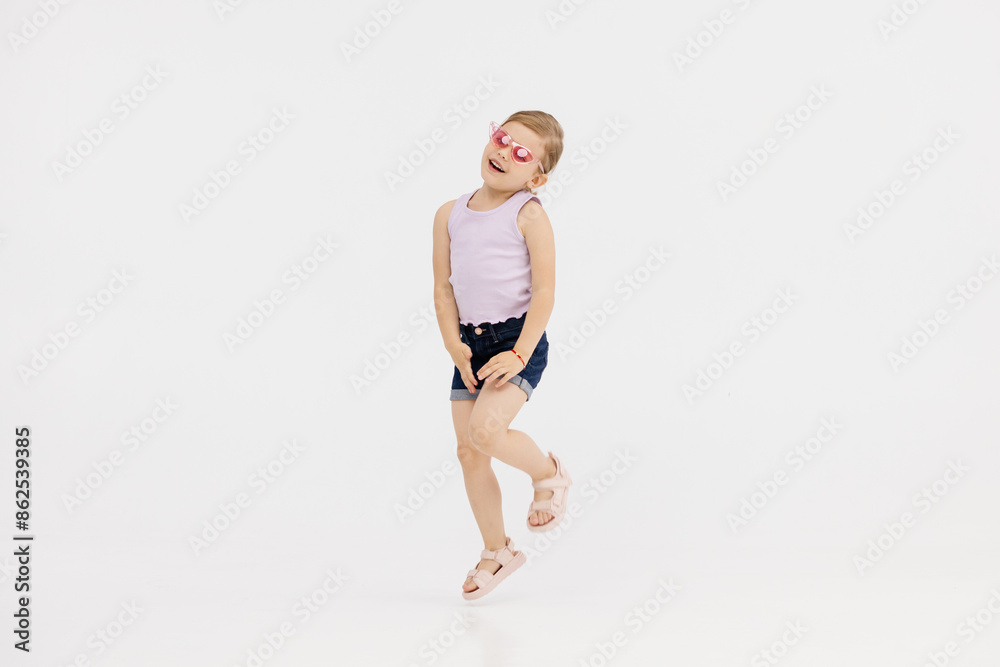 Little girl dancing in the studio on a white background. Happy energetic girl having fun and enjoying her childhood. Concept of fashion, style and happy children's emotions. Little girl dancing in the studio on a white background. Happy energetic girl having fun and enjoying her childhood. Concept of fashion, style and happy children's emotions.
