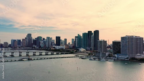An impressive aerial shot of Miamis cityscape and waterfront at sunset, featuring high-gtarise buildings, bridges, and peaceful bay waters, showcases the beauty of this iconic metropolis. 4k footage