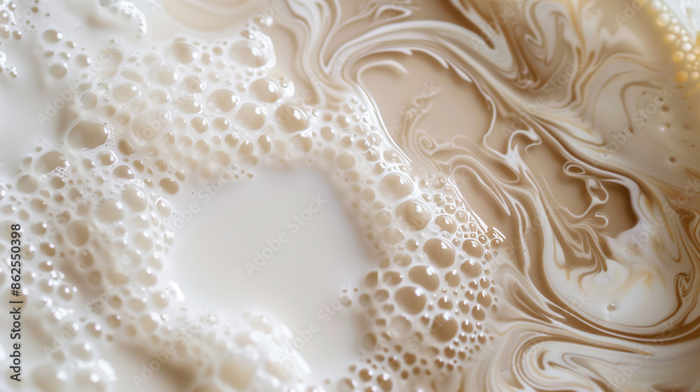 Obraz premium Large drops of milk mixed with coffee forming an abstract pattern. Milk and coffee flow smoothly into each other, creating a marble effect with bubbles on the surface