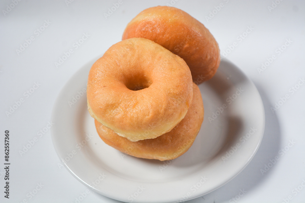 Collection of donuts on white ceramic plate, isolated objects