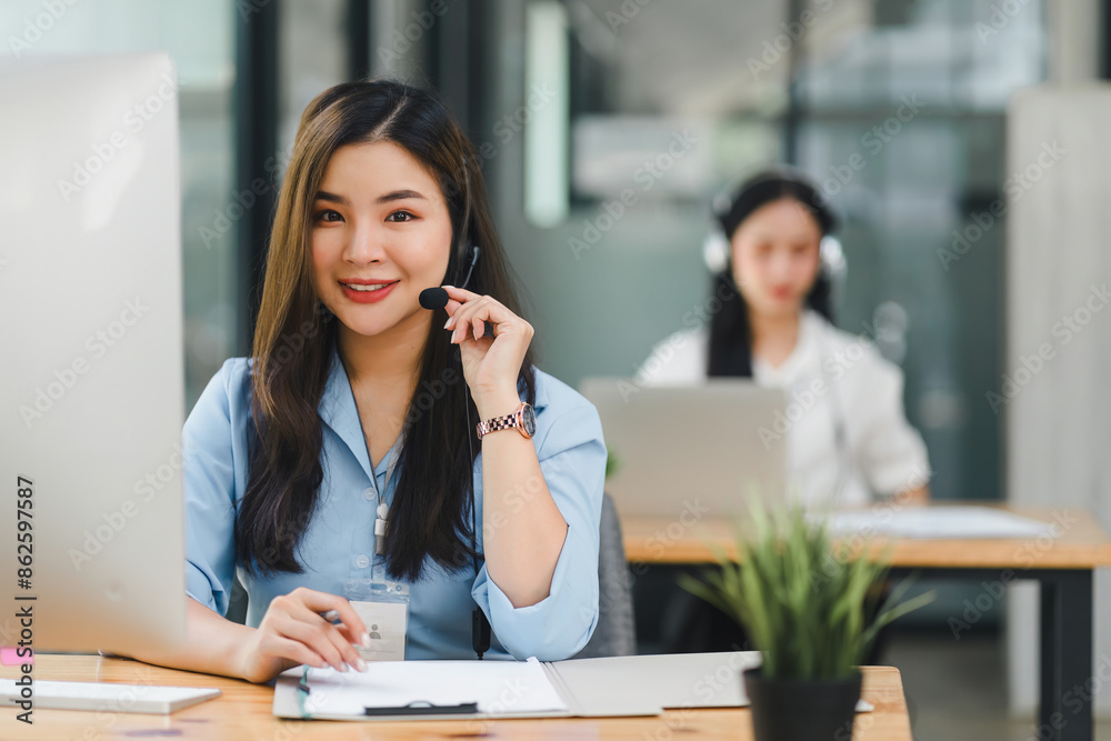 Confident asian young woman call center operator wearing headphones with a microphone. Confident asian young woman call center operator wearing headphones with a microphone.