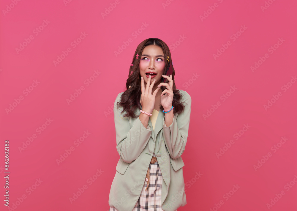 Young smiling happy asian woman 20s talking mobile cell phone gossip isolated on pink background.. Young smiling happy asian woman 20s talking mobile cell phone gossip isolated on pink background..