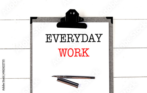 EVERYDAY WORK text on clipboard on white background photo