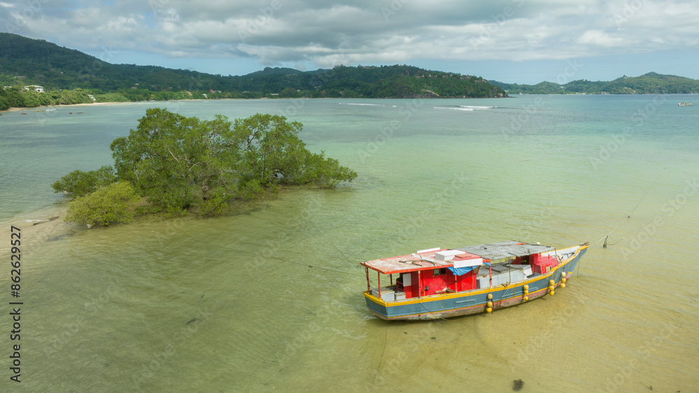 Aerial view of scenic coastal scenery with fishing boat and mangroves, Seychelles.