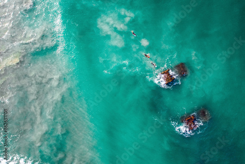 Aerial view of surfers at Belongil Beach with shipwreck, Byron Bay, New South Wales, Australia. photo