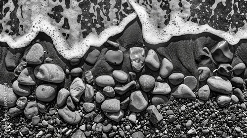 A birds eye view of the beach with pebbles tered like a mosaic. Black and white art photo