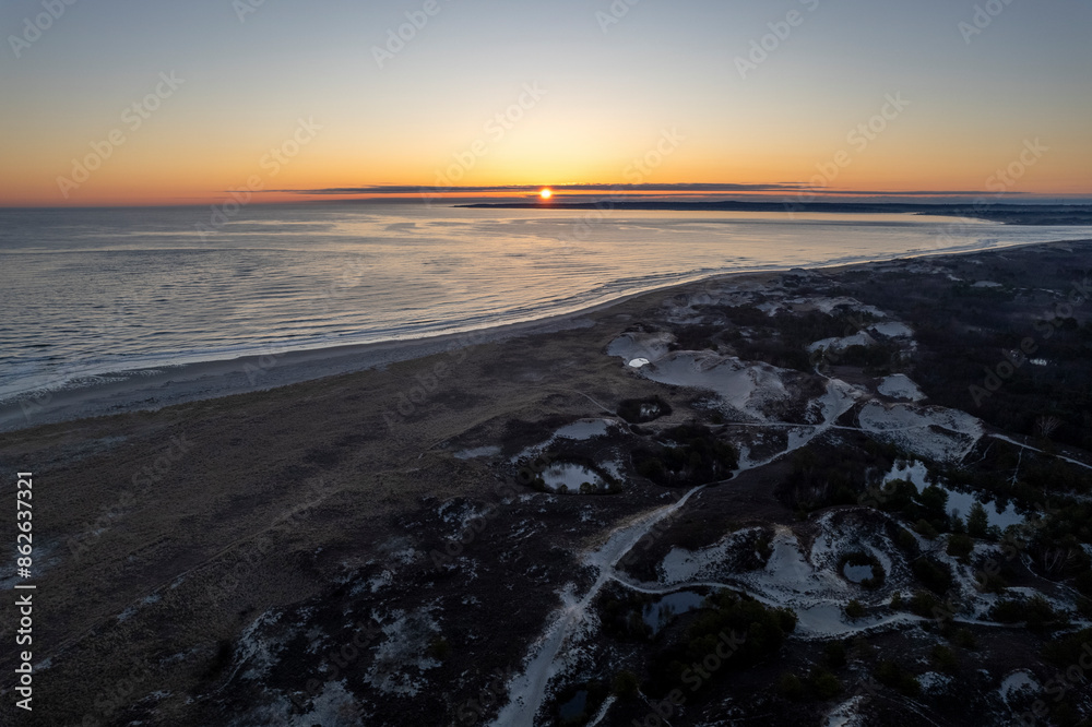 Aerial view of tranquil sunset over sandy beach and coastal dunes, Ipswich, Massachusetts, United States.