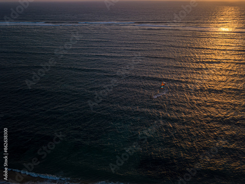 Aerial view of kite surfer riding waves during sunset in Vezo region, Anakao, Madagascar. photo