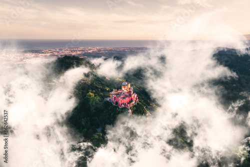 Aerial view of Pena Palace, a colourful Romanticist castle building on hilltop during a beautiful sunset, Sintra, Lisbon, Portugal.