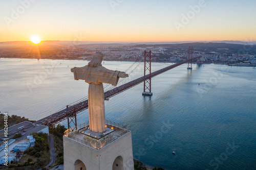 Aerial view of Cristo Rei, April 25th Bridge, and Tagus River at sunset, Almada, Portugal. photo