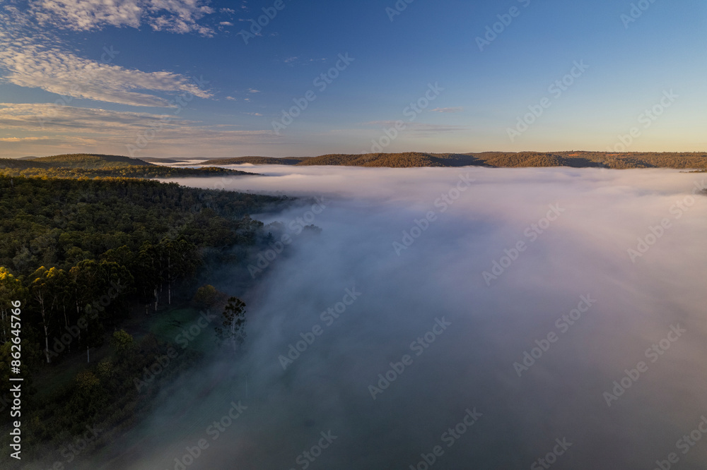Aerial view of foggy forest and cloudy sky at sunrise, Dwellingup, Western Australia.