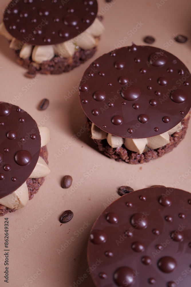 Fototapeta premium delicious dessert with chocolate cream, hazelnut praline and coffee. crispy base and chocolate decor. tasty pastry tart. modern dessert. layers. european confectionery 