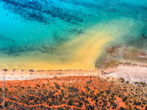 Aerial view of vibrant coastal shoreline with turquoise water and red earth, Shark Bay, Western Australia, Australia.